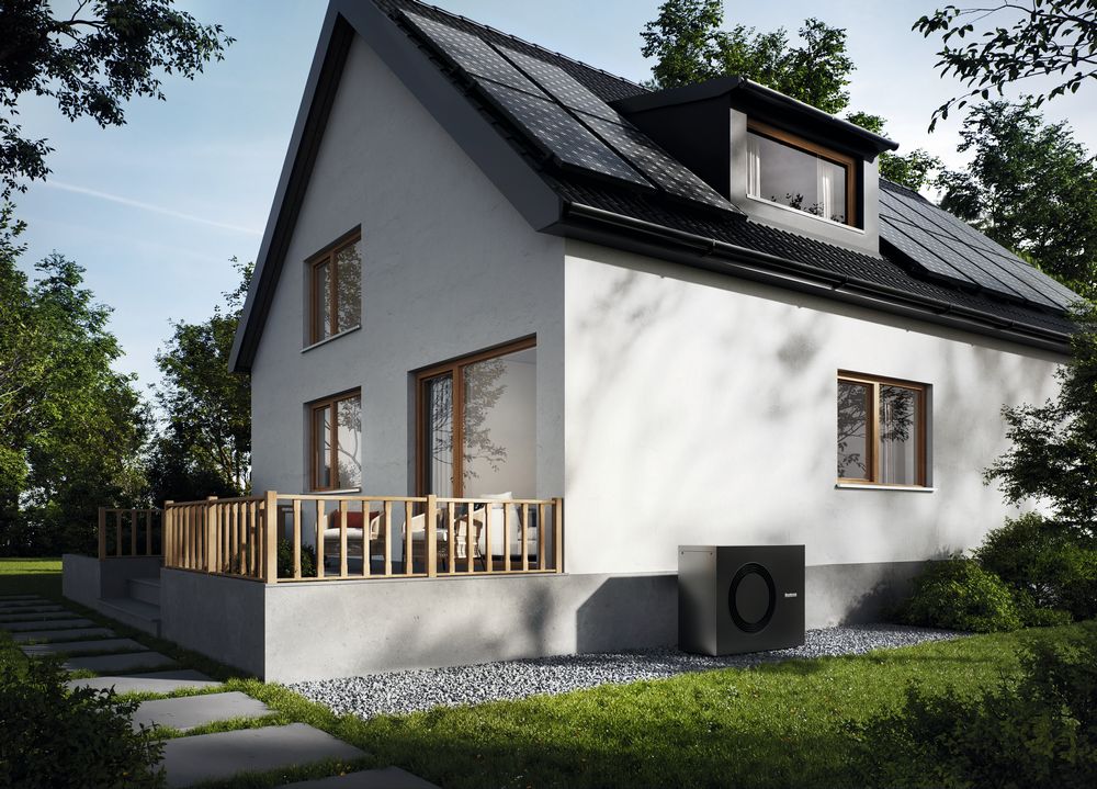 Außenansicht auf Haus mit weißer Fassade, an der Seite eine Wärmepumpe
