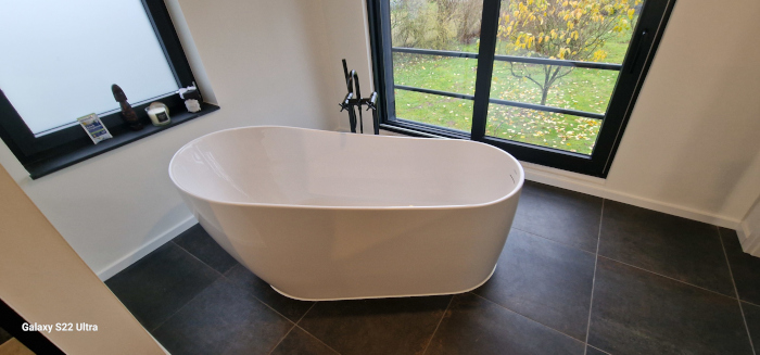 Moderne Badewanne in dunkel gefliestem Bad